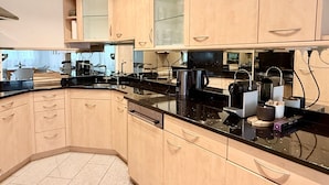 A modern kitchen with light wood cabinets, black countertops, and stainless steel appliances. - Familienfreundliche und gemütliche 3.5 Wohnung mit Garten by Interhome (Laax)