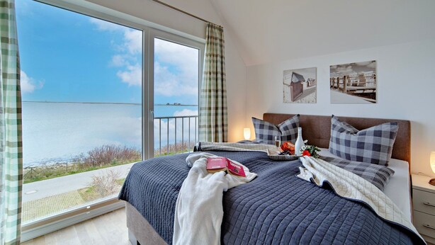 Ein Schlafzimmer mit einem großen Bett, Meerblick und einem Balkon.