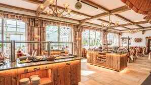 A spacious kitchen with wooden cabinets, a buffet setup, and large windows allowing natural light. - Glocknerhaus by Interhome (Berg im Drautal)