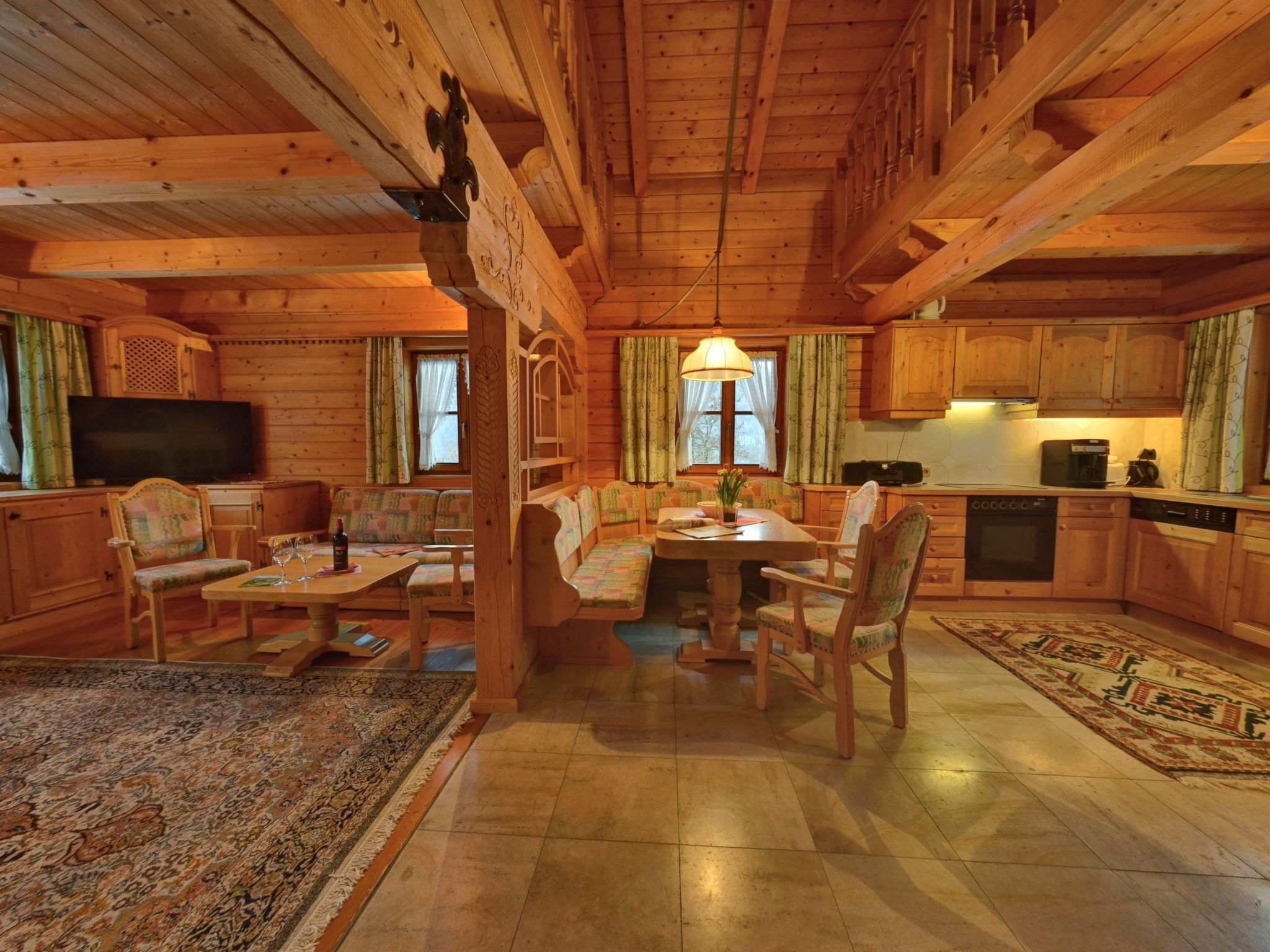Ein gemütliches Blockhaus-Interieur mit Essbereich, Küche und Sitzgelegenheiten.