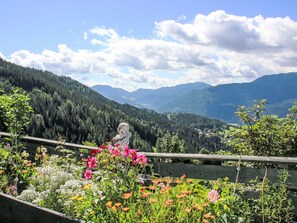 A garden with a variety of flowers and a wooden fence.