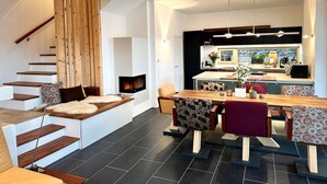Un interior moderno con una escalera, un comedor y una cocina.