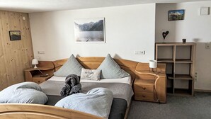 Ein ordentlich eingerichtetes Schlafzimmer mit Bett, Nachttischen, Ablagefläche und einem Wandbild.