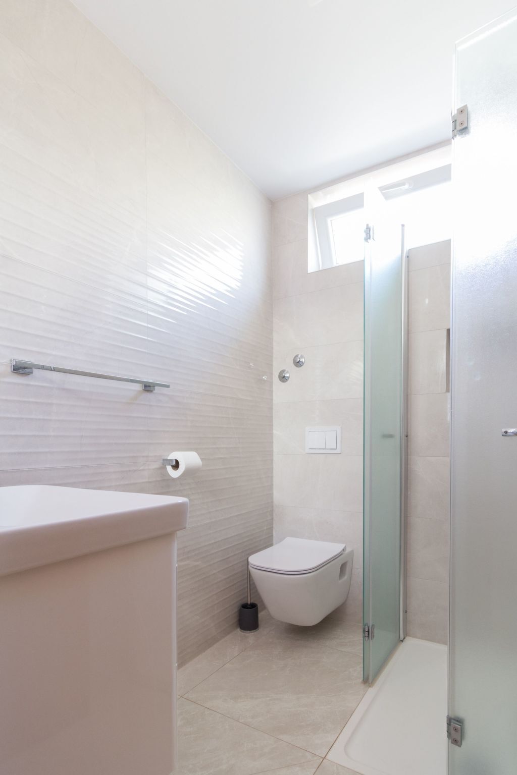 Un bagno moderno con WC, bidet e cabina doccia in vetro.
