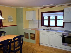 Een koelkast, een oven, kookgerei, borden en bestek