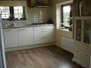 Een koelkast, een magnetron, kookgerei, borden en bestek