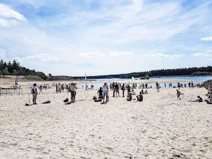 Een zandstrand met mensen en een heldere lucht.