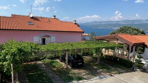 A residential property with a red-tiled roof, a pink building, and a vineyard. - Wohnung Volaric by Interhome (Polje)