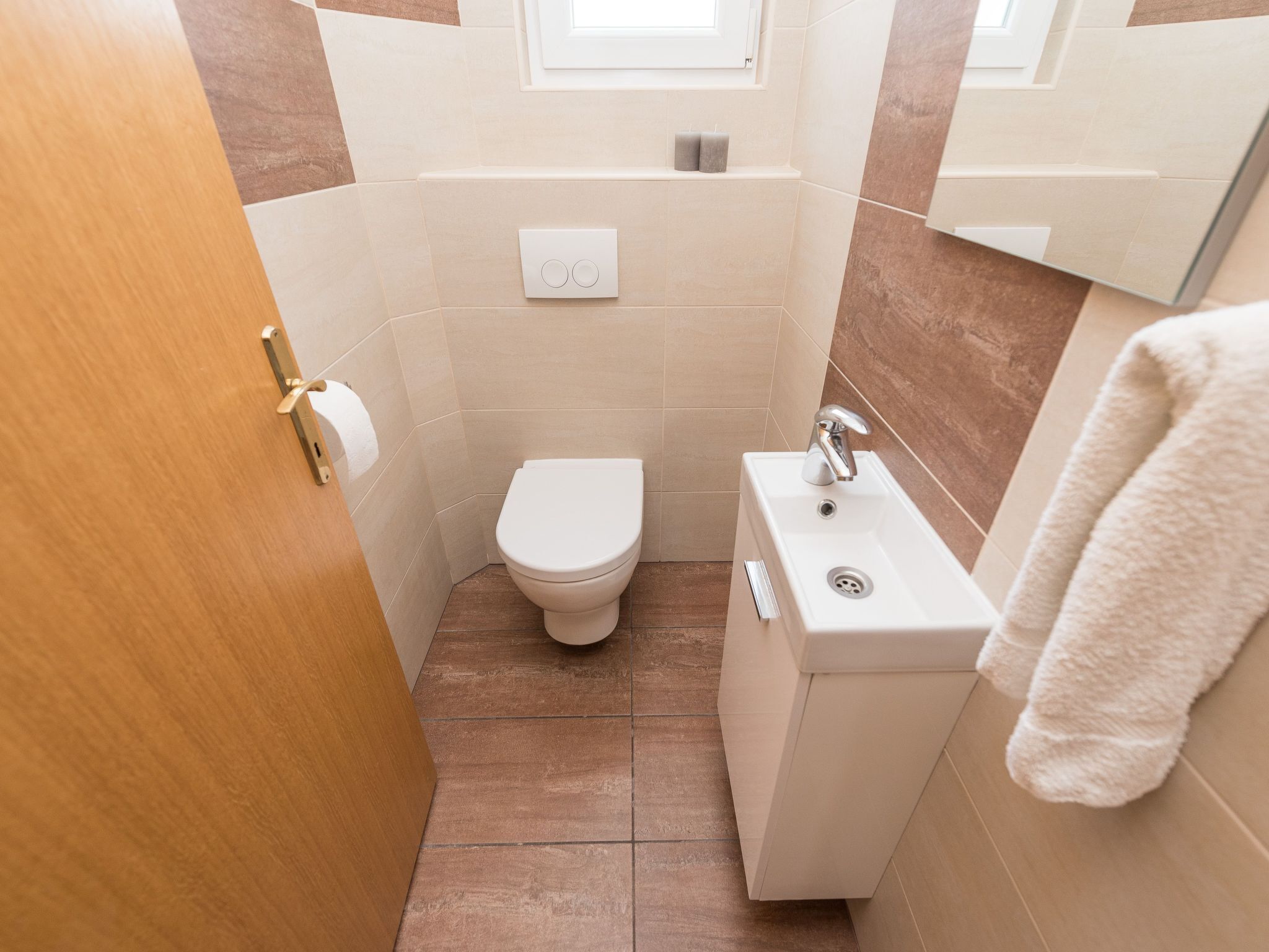 A small bathroom with a toilet, sink, and towel rack.