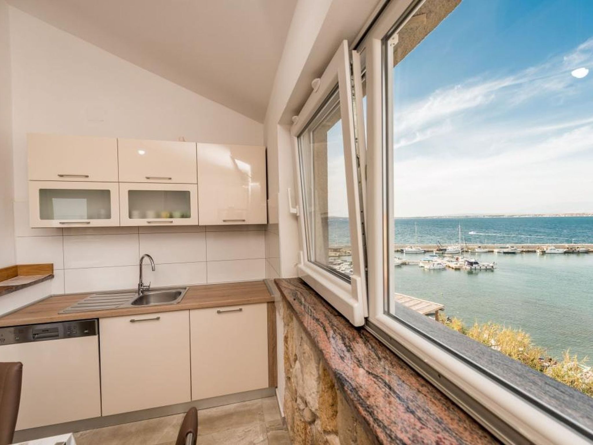 A modern kitchen with a view of a marina.