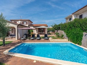 A swimming pool with lounge chairs, a covered patio, and a stone wall. - Villa Lucas by Interhome (Novigrad (Istra))