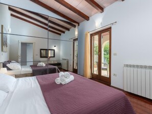 A hotel room with two beds, a large mirror, a wooden ceiling, and a view of the outdoors. - Villa Lucas by Interhome (Novigrad (Istra))