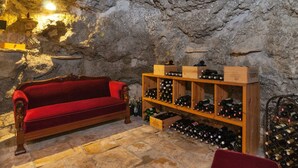 A cellar with a red velvet sofa, wooden wine racks, and stone walls. - für drei Personen by Interhome (Omiš)