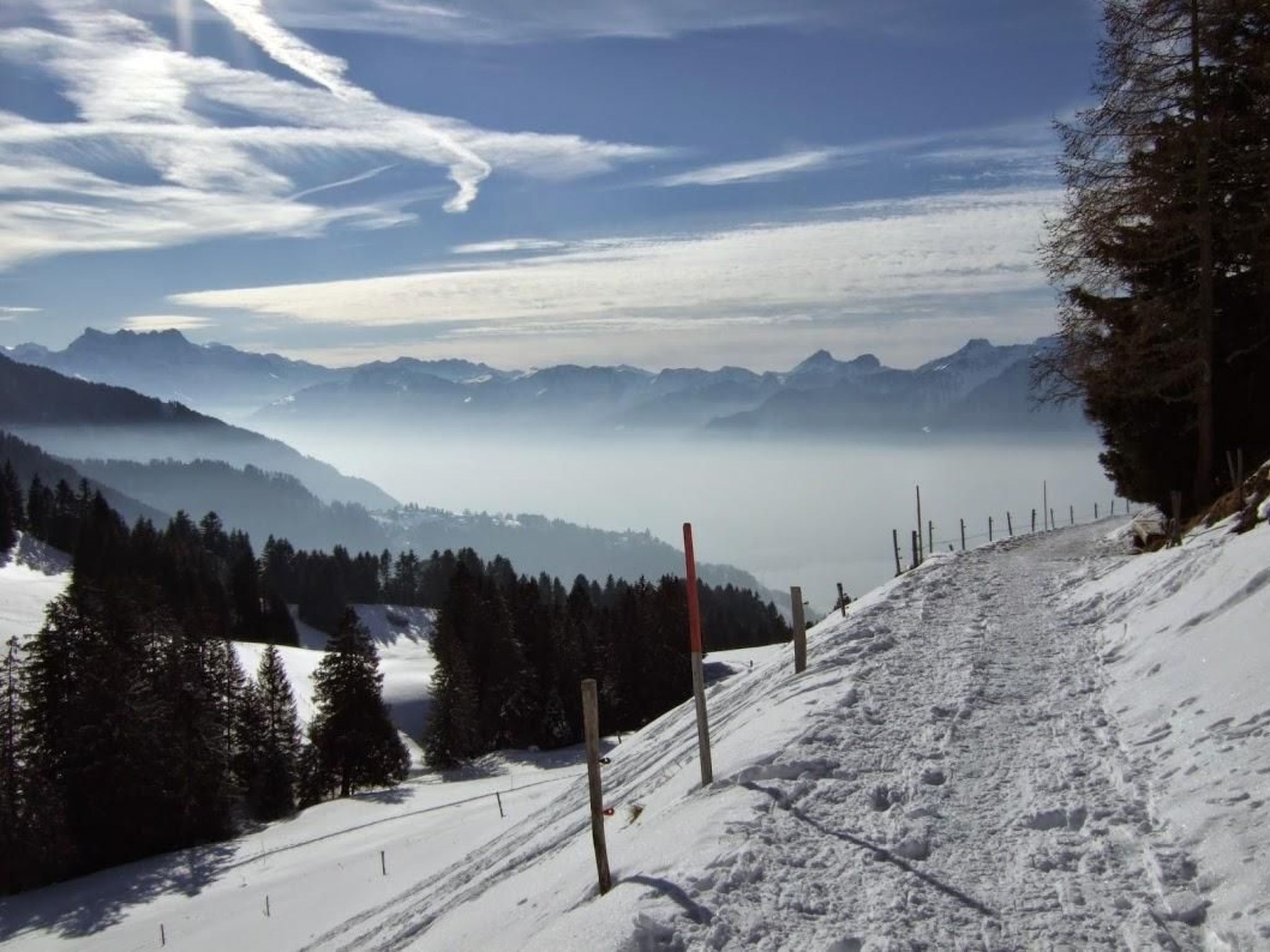 A snowy mountain landscape with a clear sky and distant mountains.