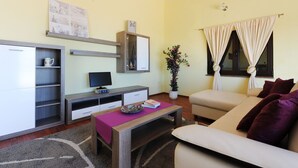 A compact living space with a sofa, a coffee table, a TV, and a small cabinet. - Wohnung "Astoria" mit Blick auf das Wasser by Interhome (Zaton)