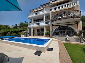 A two-story building with a swimming pool, a covered patio, and a statue. - Wohnung für 2 Pers. mit Balkon by Interhome (Novi Vinodolski)