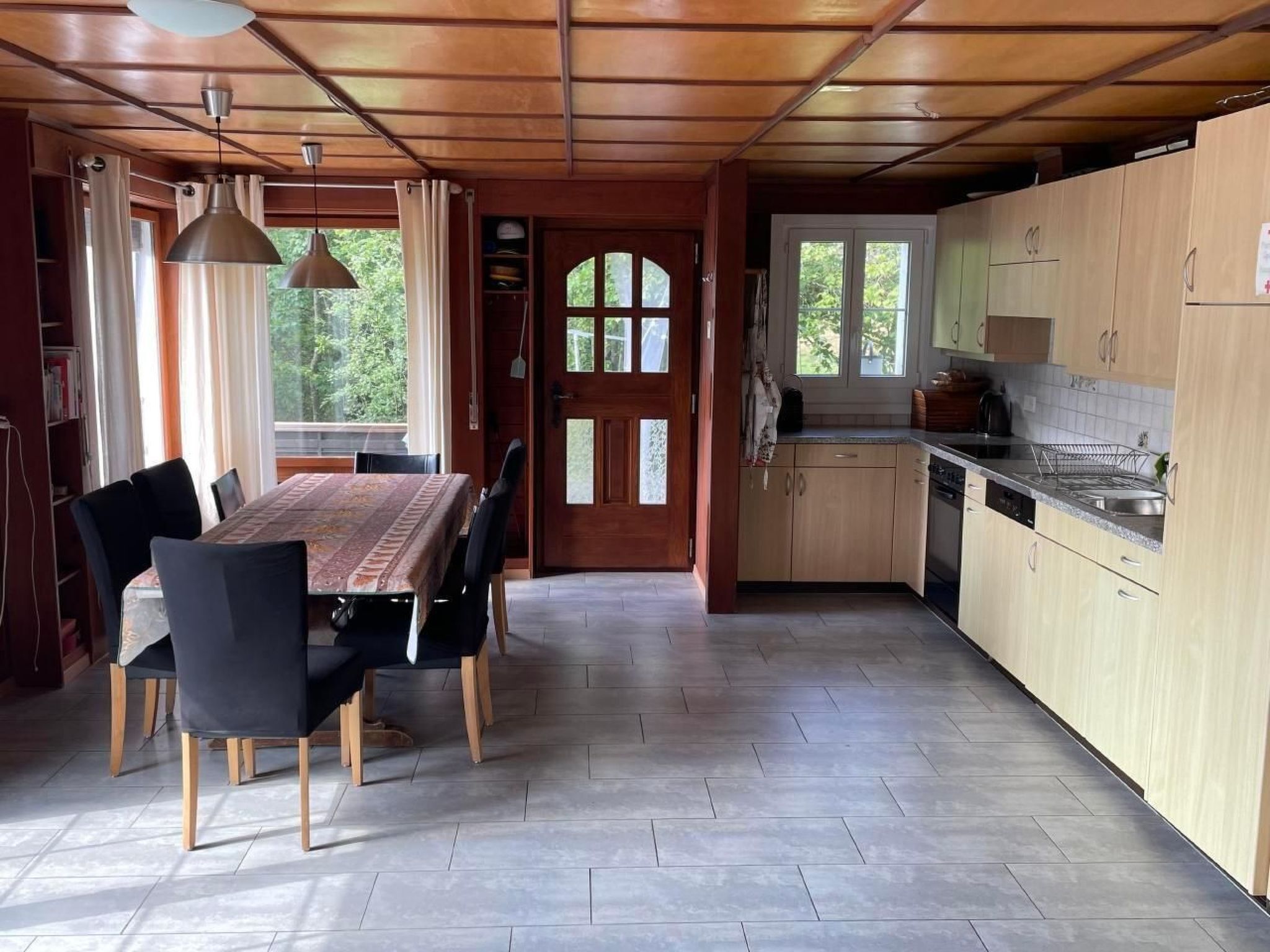 A spacious kitchen with wooden cabinets and a dining area with a table and chairs.