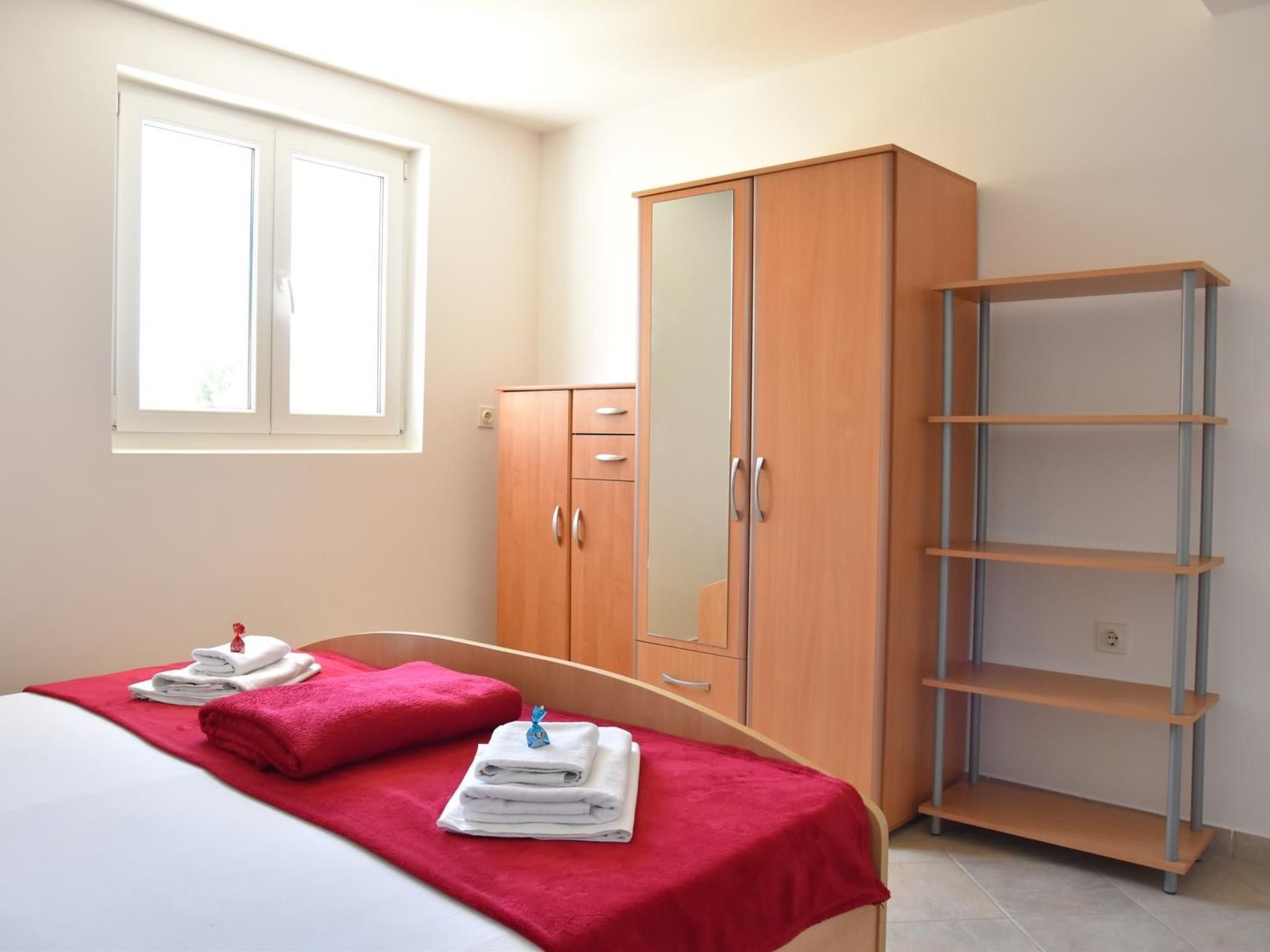 Une chambre à coucher avec un lit, une armoire et une étagère.