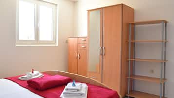 Une chambre à coucher avec un lit, une armoire et une étagère.