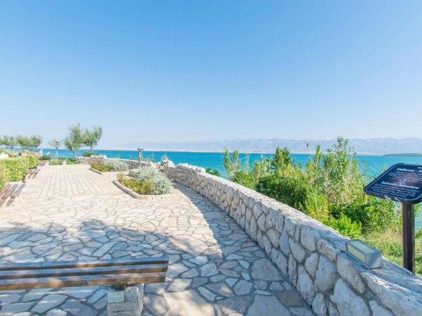 A stone pathway leading to a scenic overlook with a view of the sea and mountains. - Wohnung "Mira" direkt am Strand by Interhome (Privlaka)