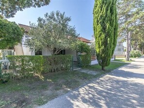 A residential property with a paved driveway, a well-maintained lawn, and a tall, slender tree. - Wohnung Barby nahe Sandstrand - Agentur TA Leut by Interhome (Privlaka)