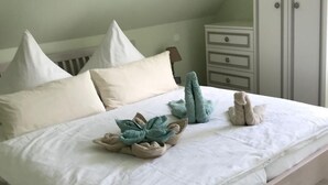Una camera da letto con un letto, cuscini, un comodino e un armadio.