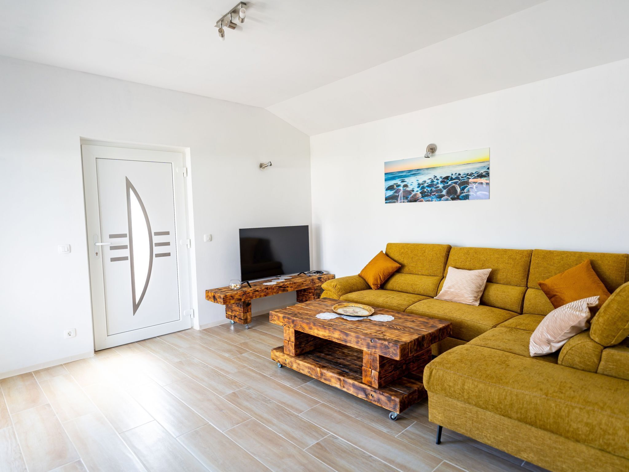 Ein Wohnzimmer mit einer Couch, einem Fernseher und einem Couchtisch aus Holz.