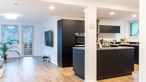 Una cocina moderna con una isla central, electrodomésticos integrados y un amplio ventanal que proporciona luz natural.