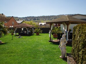 A well-maintained backyard with a gazebo, a statue, and a lawn.