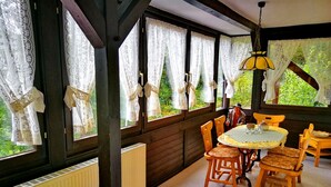A cozy room with wooden beams, lace curtains, and a table with chairs. - Chalet Wiedfluh in Waldbreitbach by Interhome (Waldbreitbach)