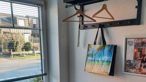 A room with a wooden chair, a wall-mounted shelf with a painting, and a window with blinds. - Glückstreffer by Interhome (Meppen)