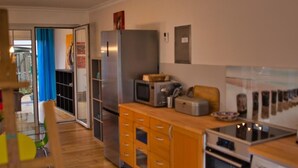 A compact kitchen with a refrigerator, microwave, toaster, and oven. - Glückstreffer by Interhome (Meppen)