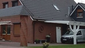 Een twee verdiepingen tellend huis met een schuin dak, een garage en een overdekte oprit.