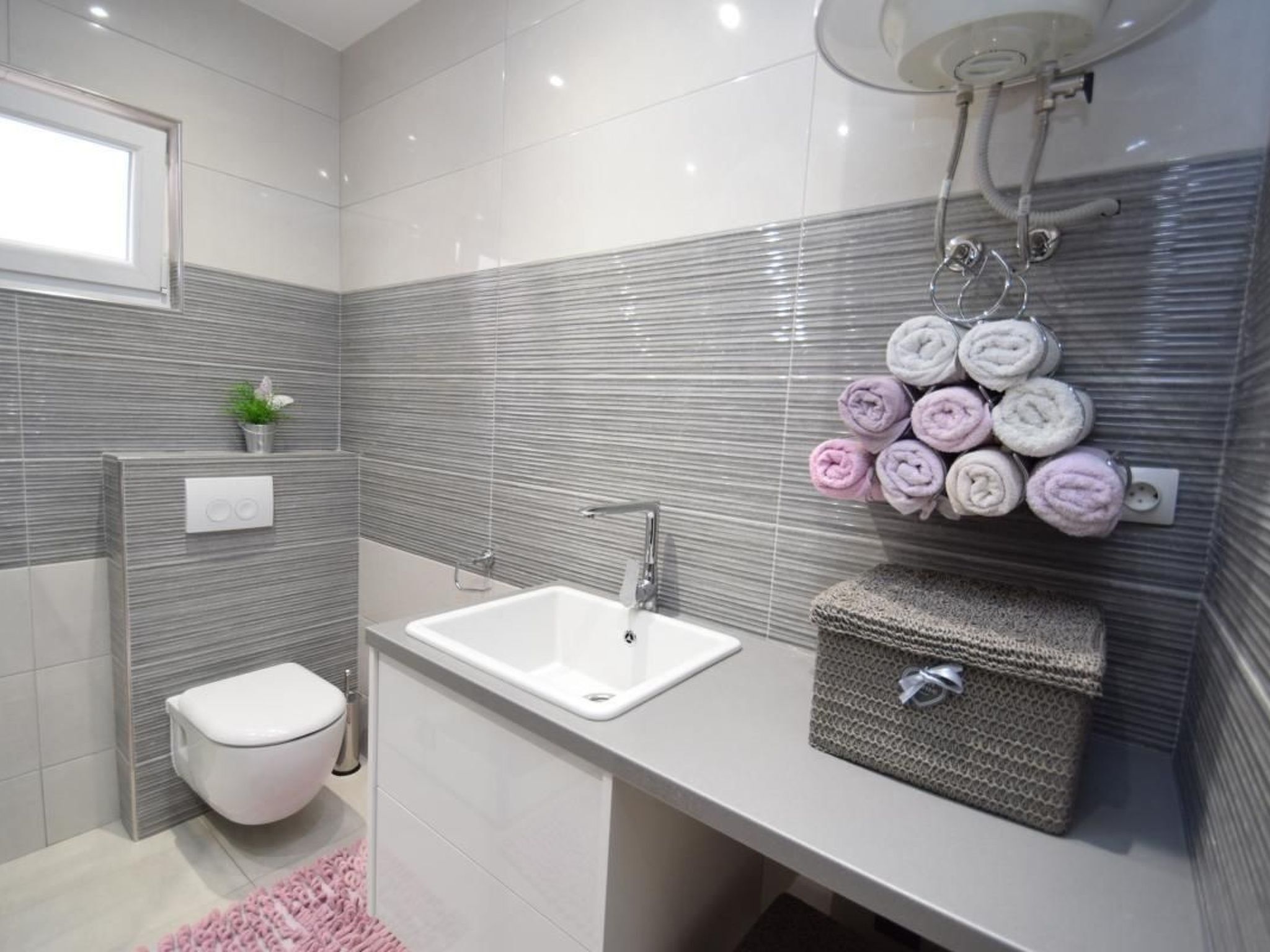A modern bathroom with a white toilet, a bathtub, and a sink.