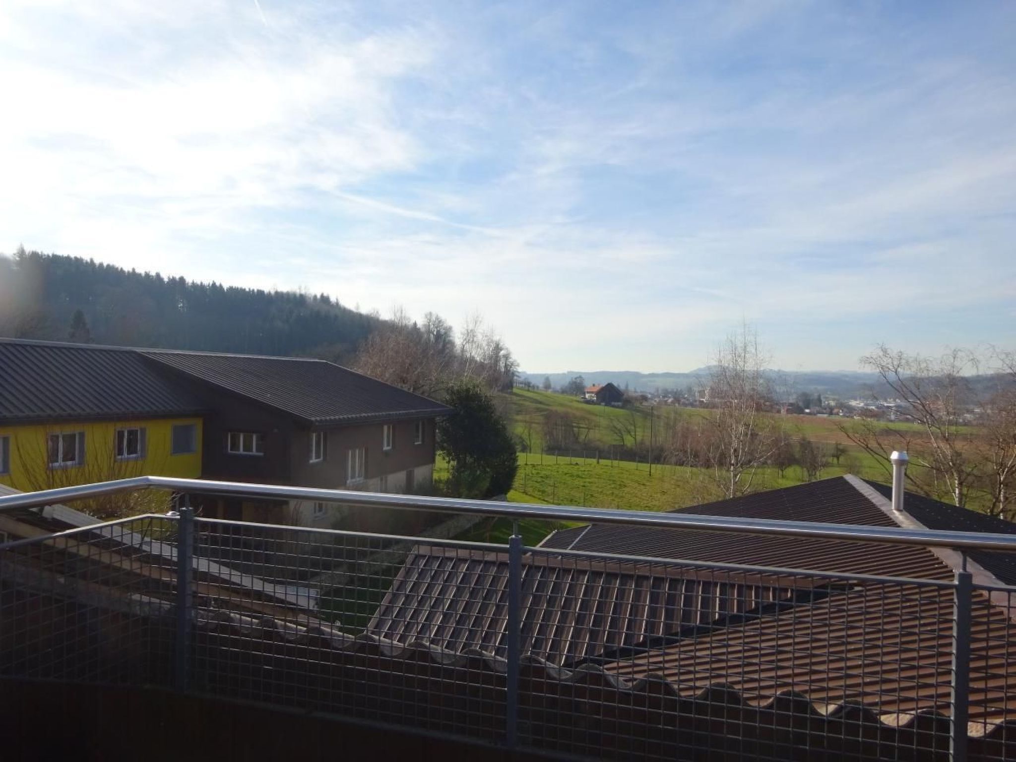 Una zona residencial con casas, cielo despejado y un paisaje montañoso al fondo.