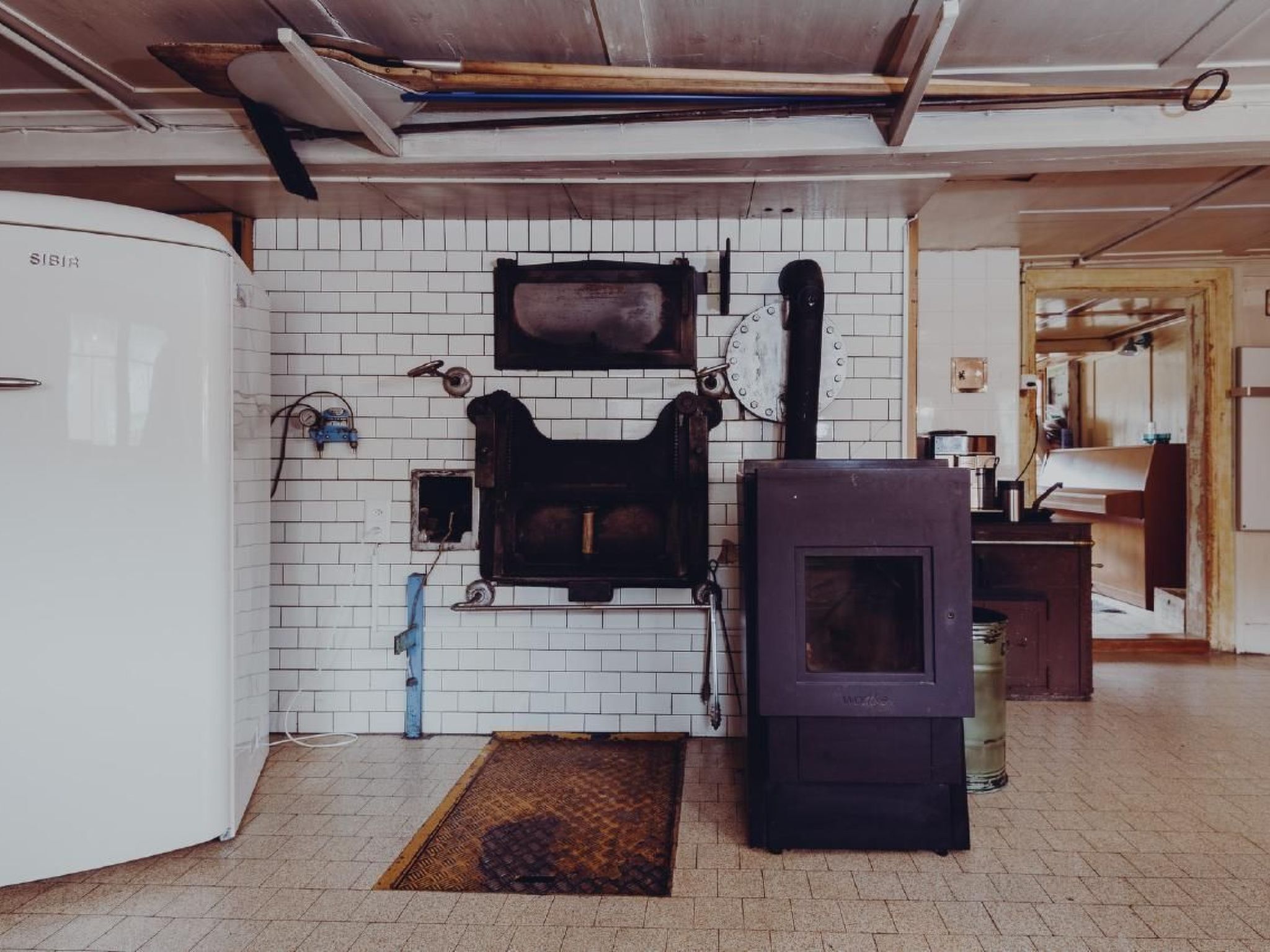 Una cocina con un refrigerador blanco, una estufa y un reloj en la pared.