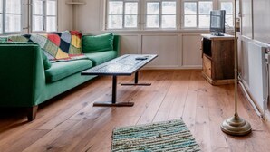 A cozy room with a green sofa, a wooden coffee table, and a floor lamp. - Lindeli by Interhome (St. Peterzell)