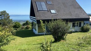 Een modern huis met een schuin dak, een kleine garage en uitzicht op zee.