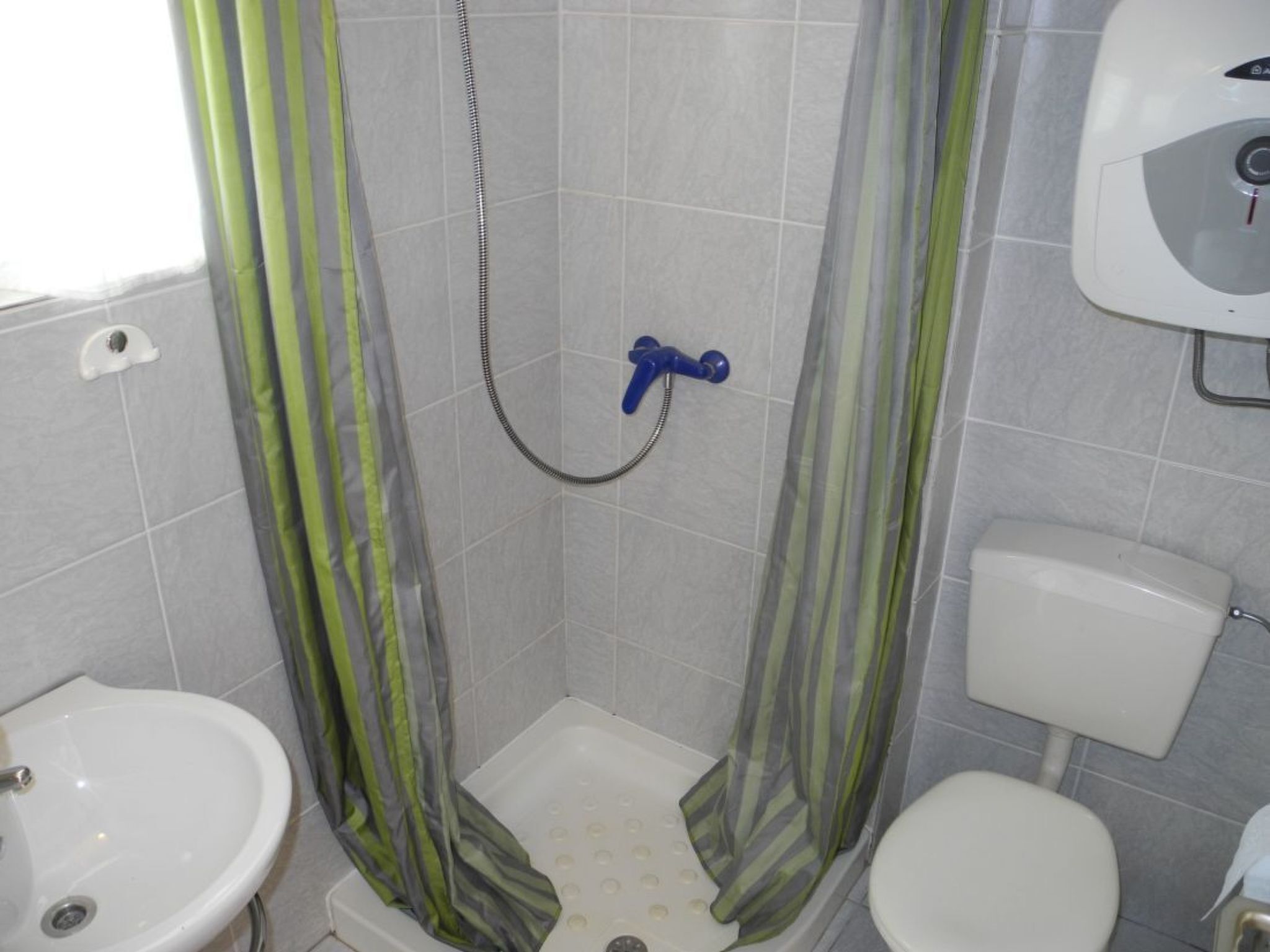 A bathroom with a shower, toilet, and sink.
