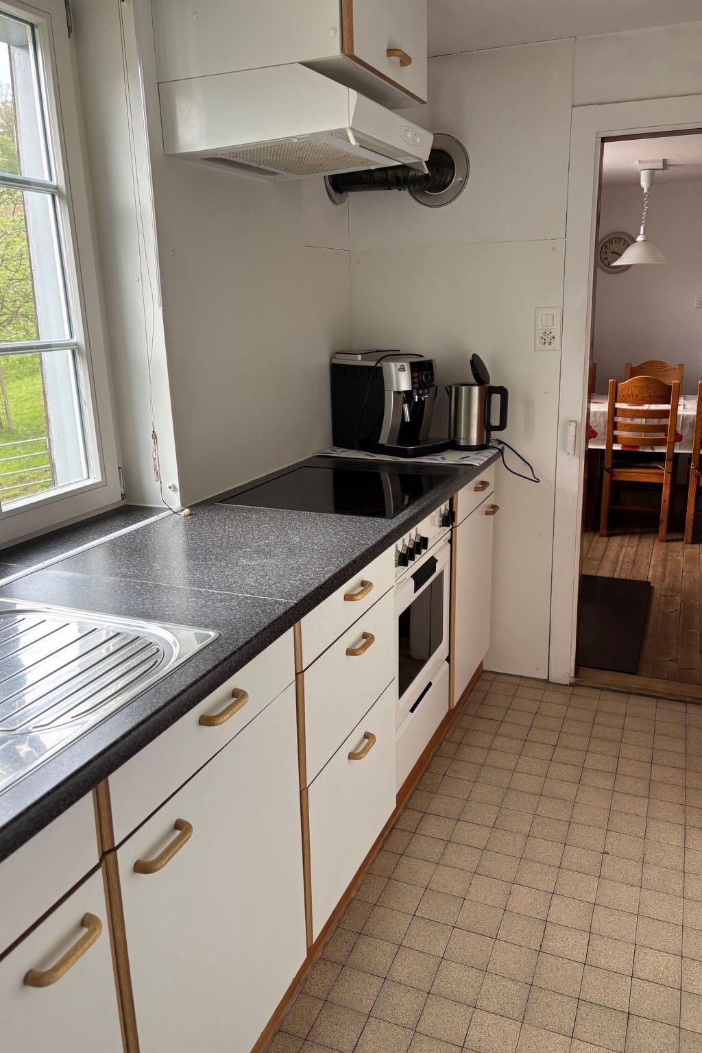 Een koelkast, een oven, kookgerei, borden en bestek