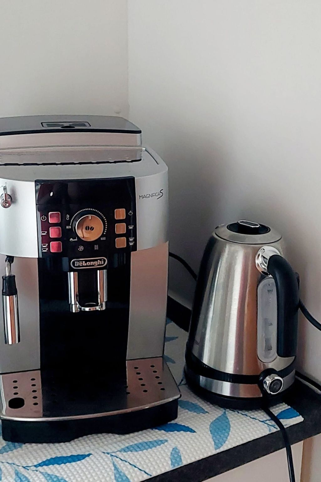 En kaffemaskin med en kontrollpanel och en vattenkokare placerade på en bänkskiva.