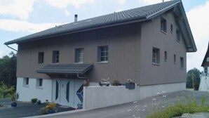 Ein zweistöckiges Gebäude mit Satteldach und Garage.