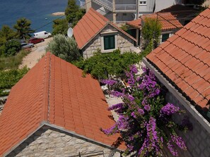 A coastal residential area with terracotta-roofed houses, a stone pathway, and a view of the sea. - Große Ferienwohnung in Omiš mit Privatem Balkon by Interhome (Omiš)