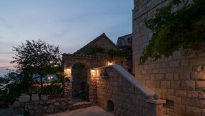 A stone building with a small archway and steps leading up to a balcony. - Kleine Wohnung in Omiš mit Privatem Balkon by Interhome (Omiš)