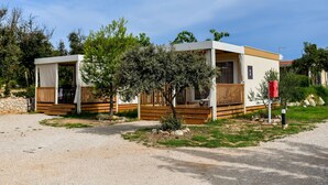 A single-story, modern mobile home with a wooden deck and a covered porch. - Mobilheim direkt am Strand by Interhome (Ugljan/Ugljan)