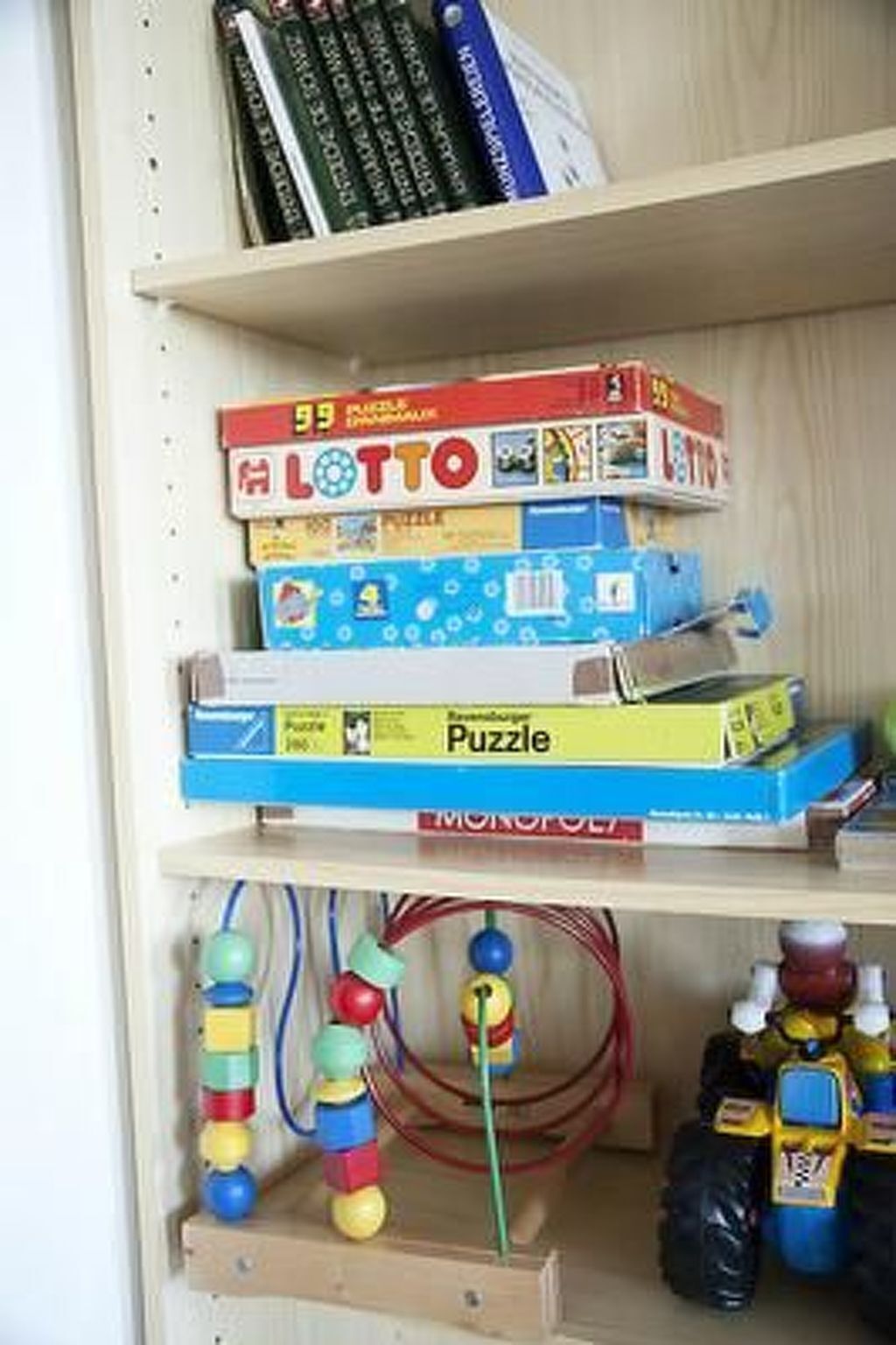 A shelf with various board games and puzzles.