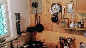Una cocina compacta con estufa a gas, un lavamanos y gabinetes de madera.