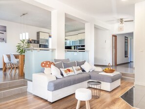 A modern living room with a sectional sofa, a dining area with chairs, and a kitchen in the background. - Villa Maslina mit privatem Pool in ruhiger Lage by Interhome (Nin)
