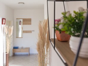 A modern bathroom with a wooden bench, a mirror, and pampas grass decorations. - "Jasmin" by Interhome (Nin)