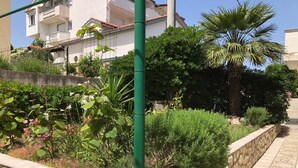 A garden with various plants and a stone wall. - The Blue Line Ferienwohnung mit Balkon by Interhome (Rab/Kampor)